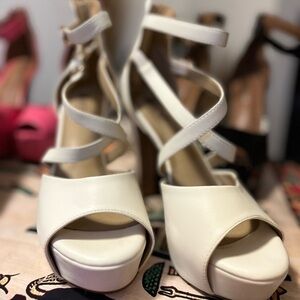 White stilettos with two straps, cross feet.